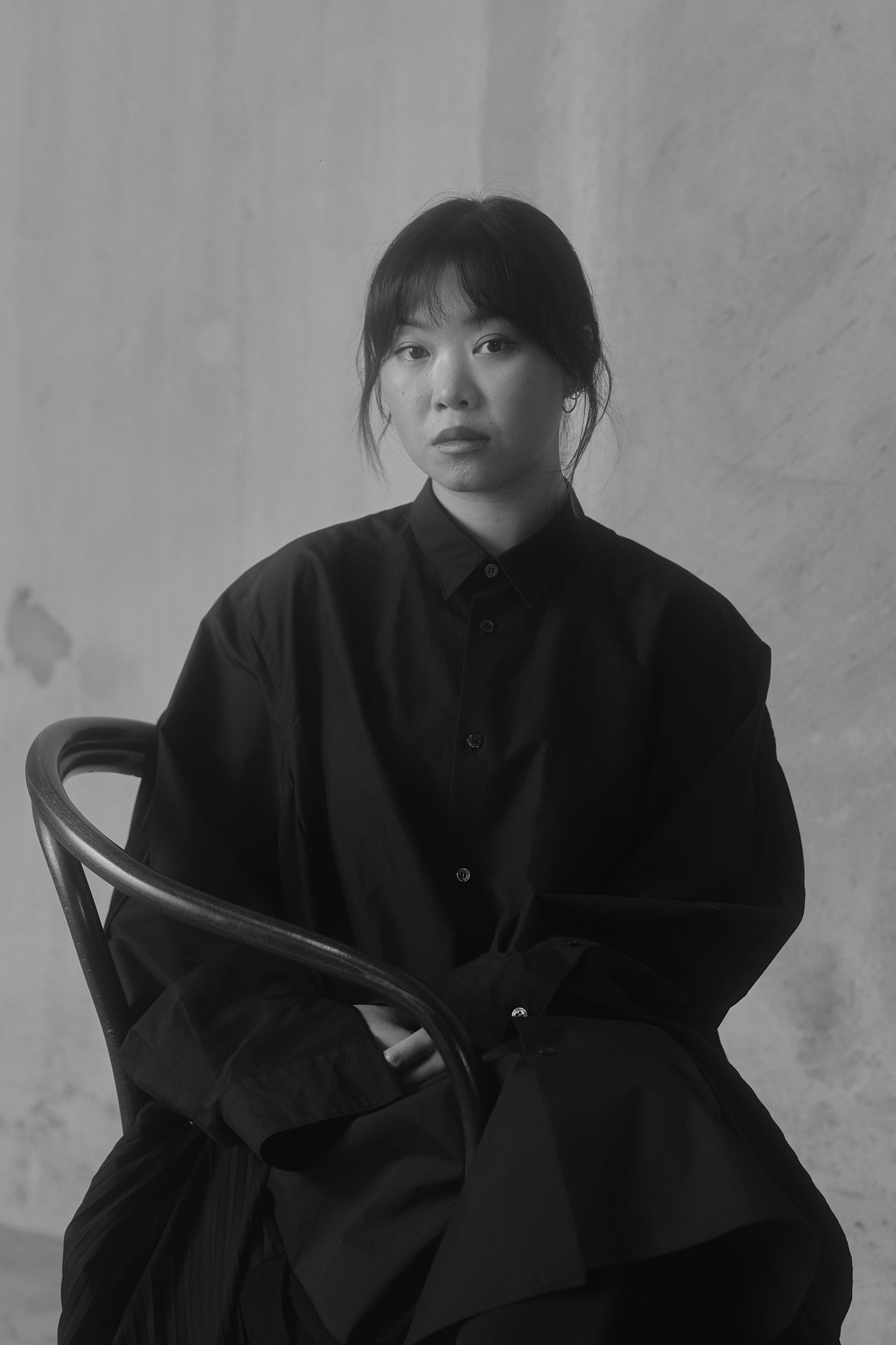 Portrait of Angela Tam in a black Issey Miyake dress, captured as a black and white photograph.