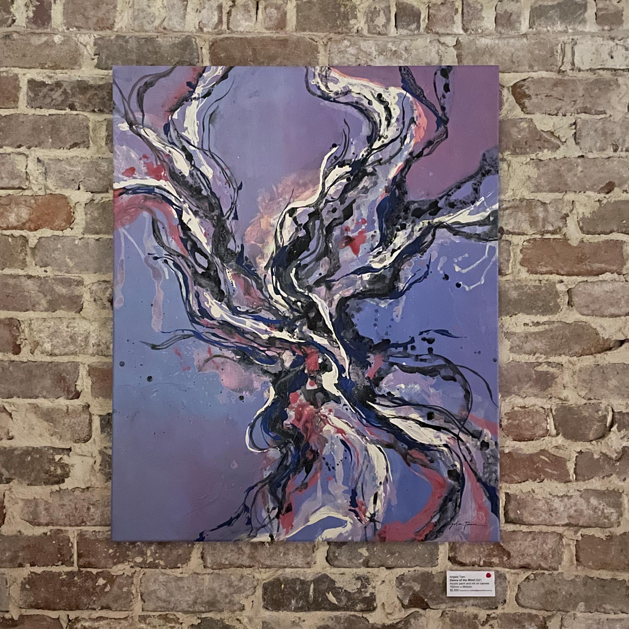 Purple abstract painting by Angela Tam showcased on the brown brick wall of a gallery.