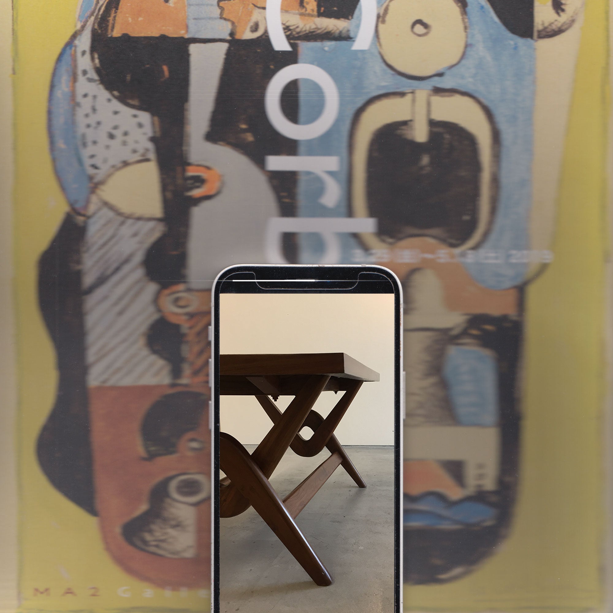 A yellow and blue poster of Le Corbusier's painting, displayed as a poster. An iphone is in the foreground with an image of a wooden table designed by Le Corbusier.