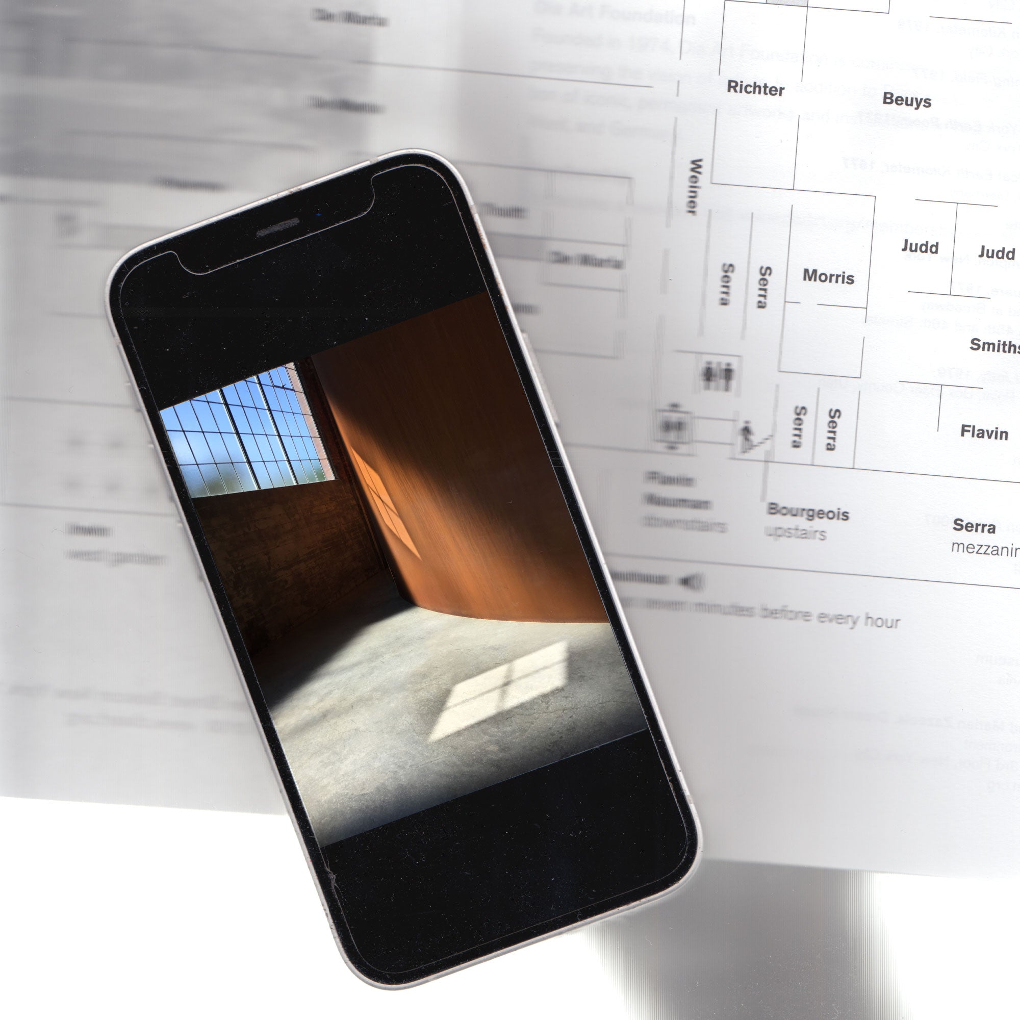 A scanned image of an exhibition floor plan of the DiA in New York. An iphone is also scanned with a color image of Richard Serra's sculpture at DiA displayed.