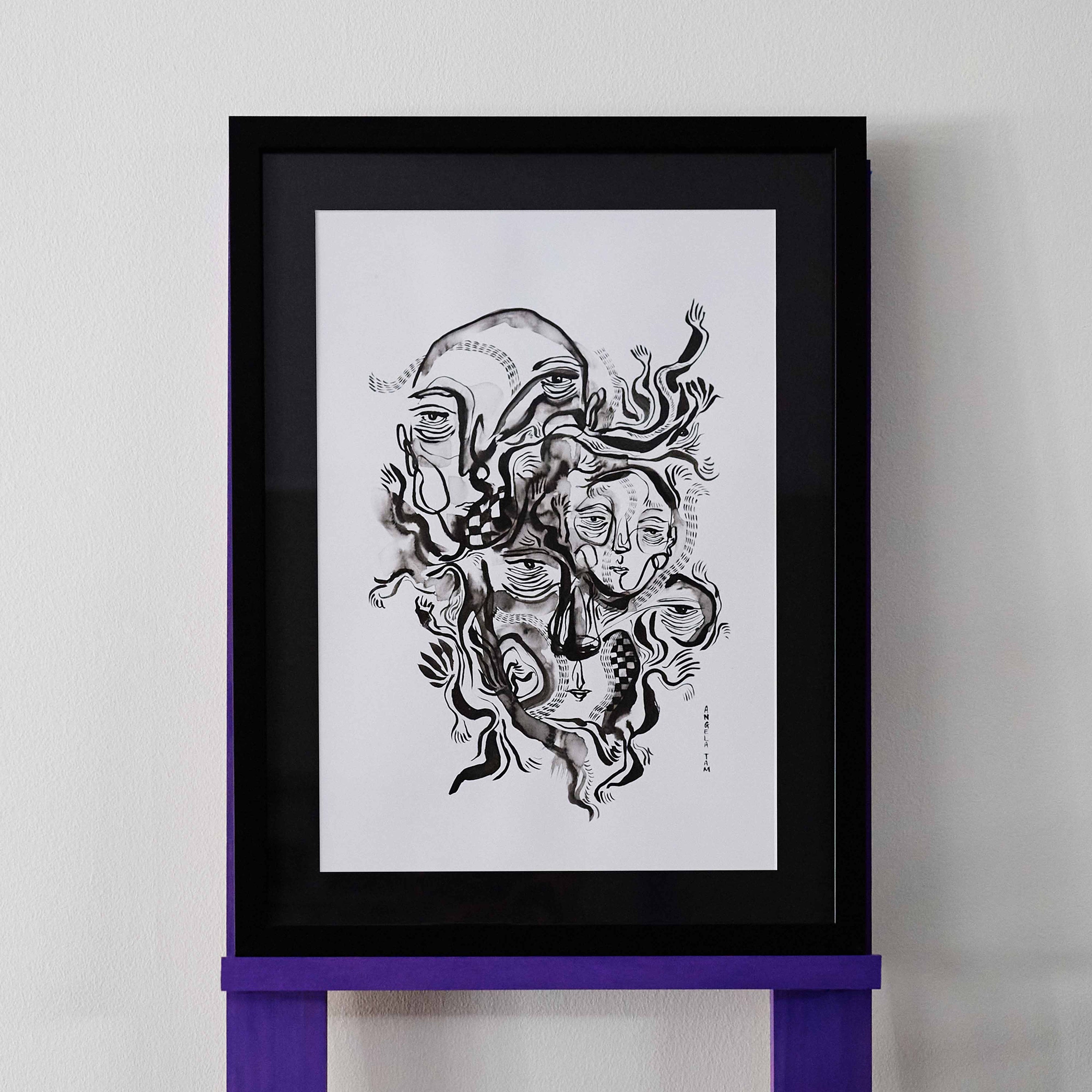 'Embodied' is an original ink painting by Angela Tam featuring three abstract faces and a combination of fluid brushstrokes and checks. Displayed on a black mount and black frame.
