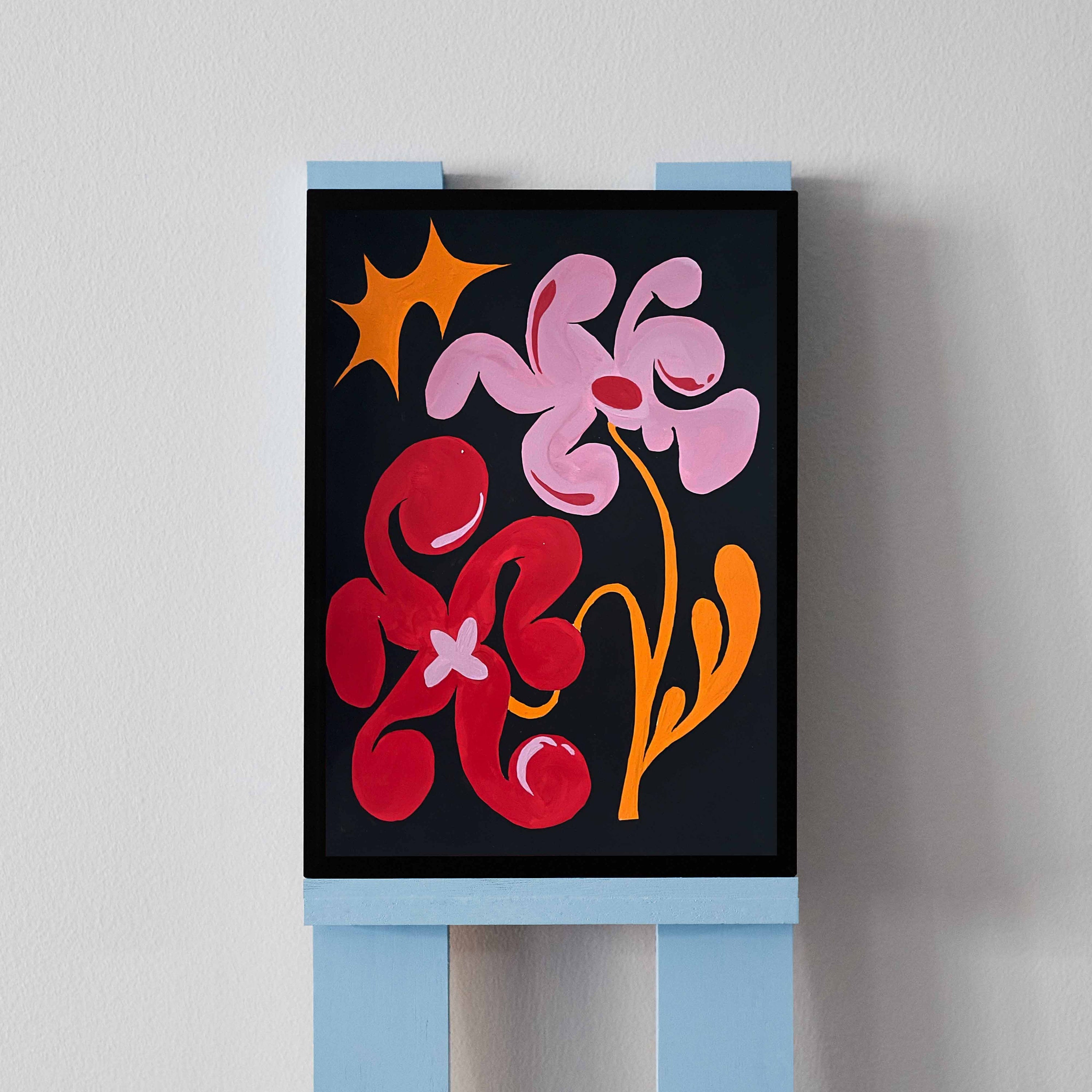 'Flower Arrangement 10' is an original acrylic painting by Angela Tam. Two surreal shaped flowers in red and pink stem from an orange wavy stem. Contrasted to the black background, the vibrant botanicals create a bold macro view into a night garden. Displayed on a black frame.