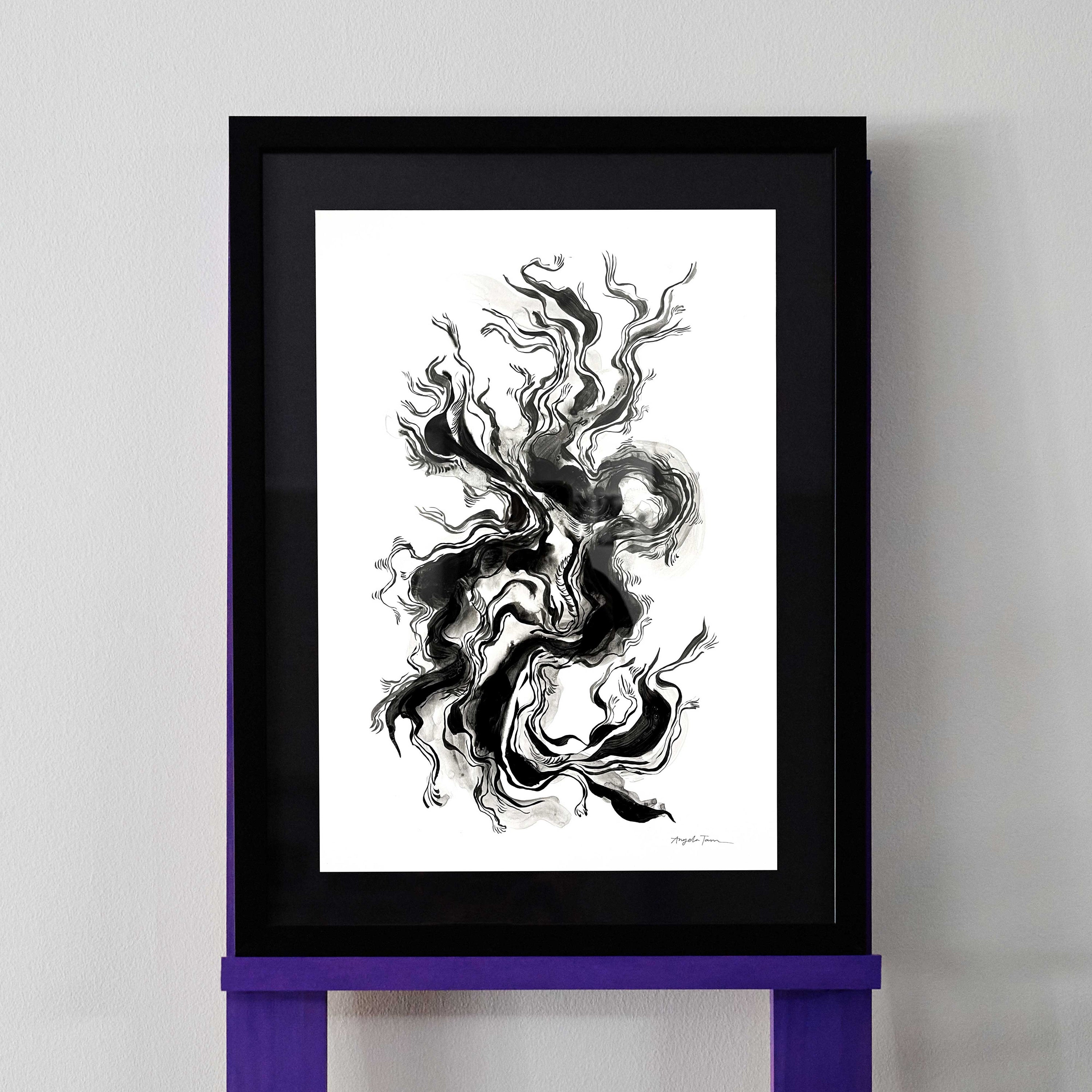 Black and white fluid ink drawing revealing lines that show eyes and a face. The artwork is pictured in a black frame.