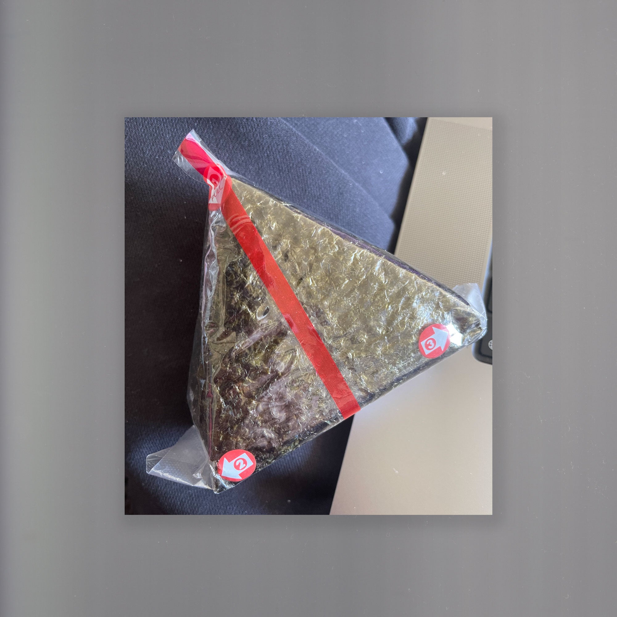 An image of a Japanese onigiri food wrap with red graphic elements displayed on the packaging.